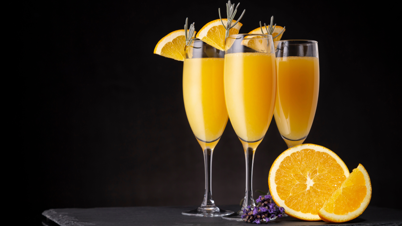 3 fancy mimosas, one of the best drinks of 2024, against a black background