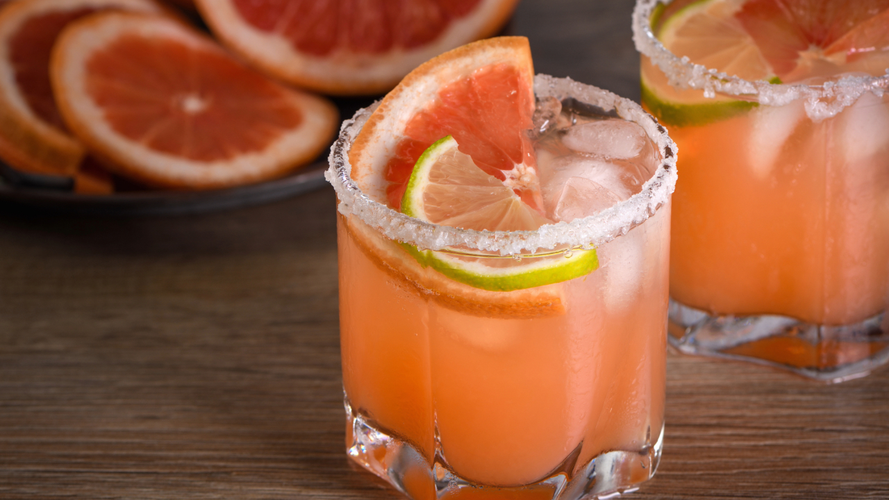 A paloma, one of the best bar drinks of 2024, surrounded by grapefruits for garnish