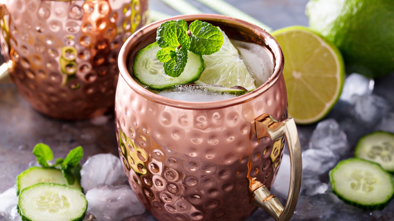 A close up of a Moscow Mule, one of the best bar drinks 2024, with lime, mint and ice