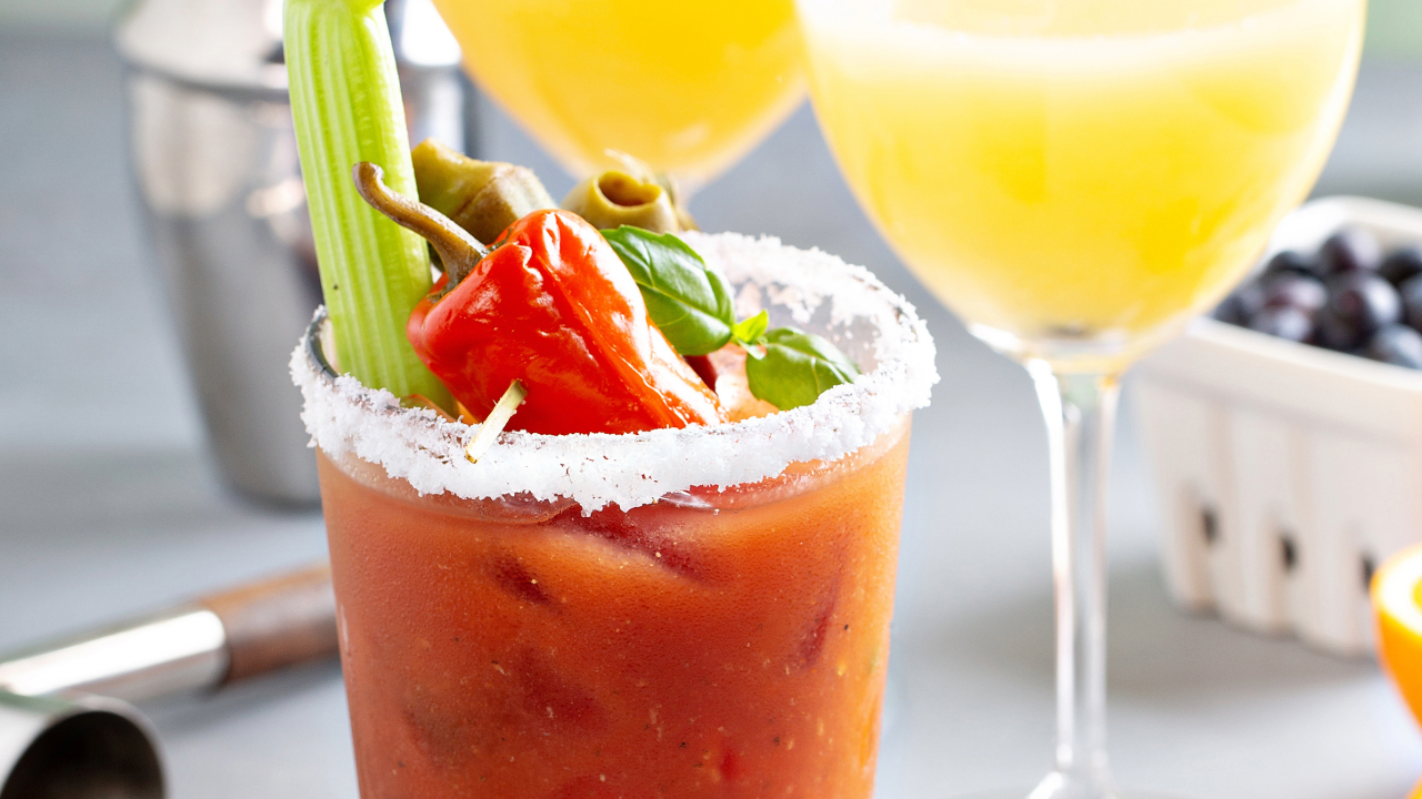 A fancy Bloody Mary cocktail with a salted rim and various other garnishes