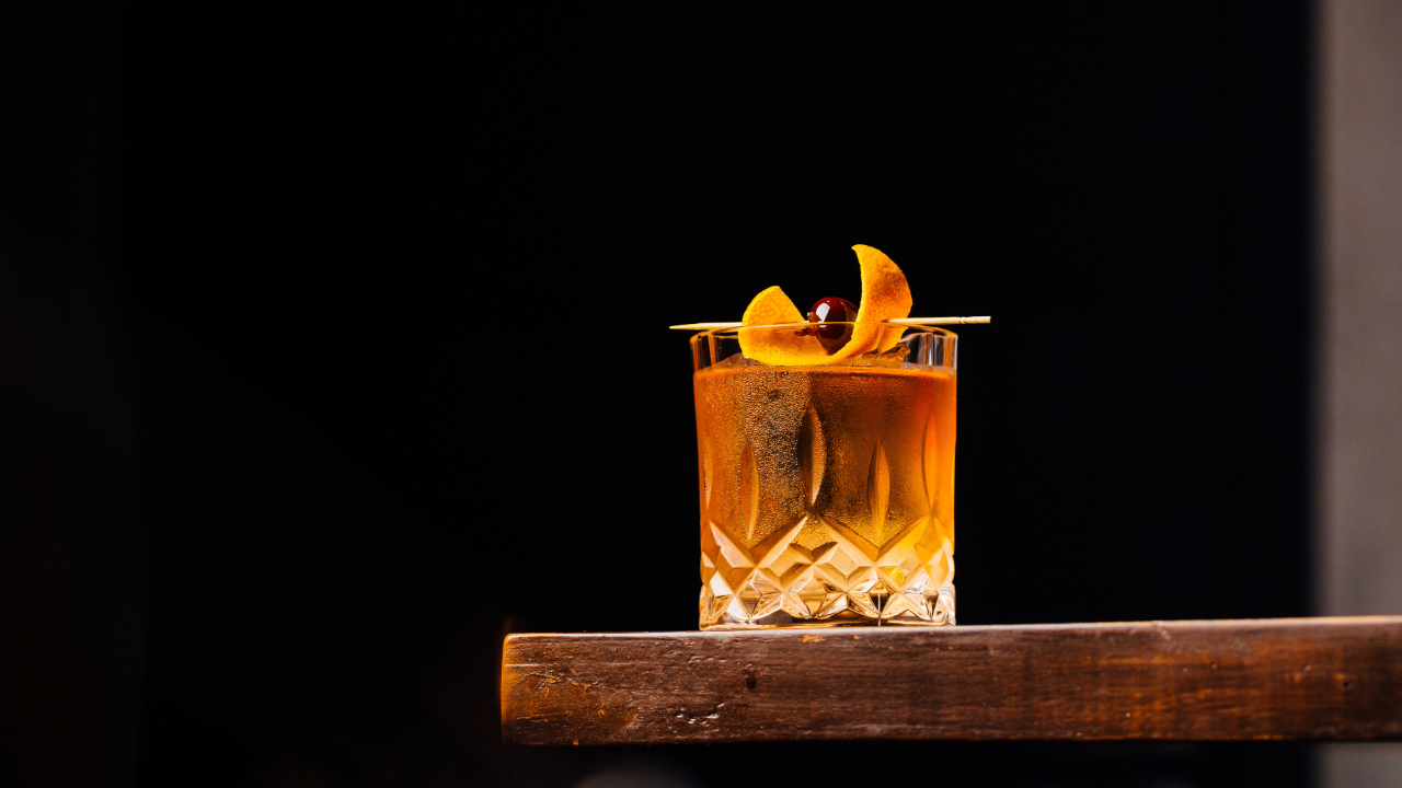 An old-fashioned cocktail with bitters and various other elegant garnishes