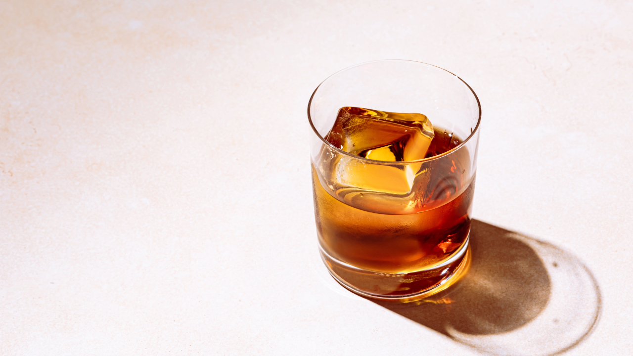 An overhead shot of a glass of premium whiskey with a large ice cube