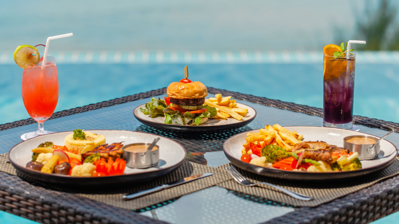 3 plates of delicious food with the perfect drinks to pair them with by a pool