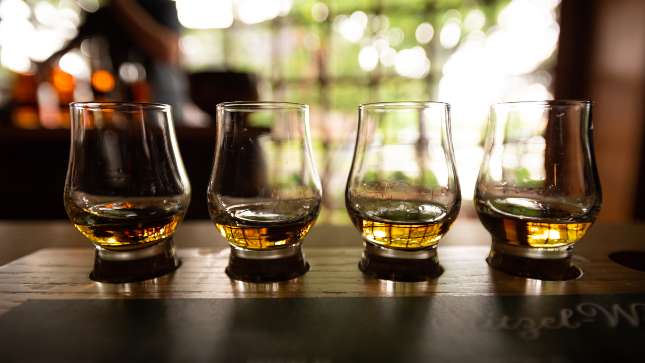 Several Bourbon Tasting Glasses in an elegant, low-lit bar setting