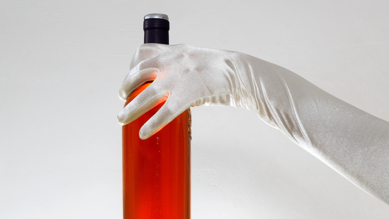 A picture of a rare bottle of spirits held carefully with elegant white gloves