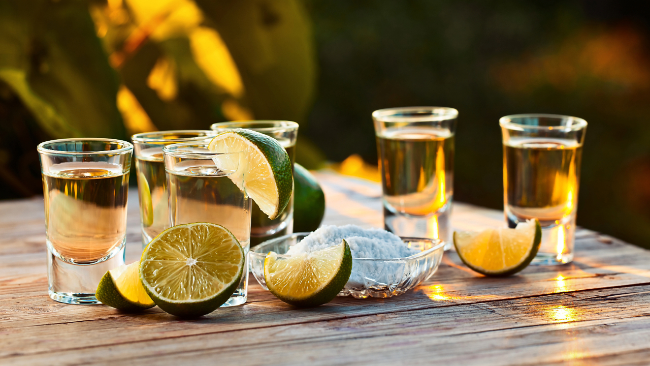 A table of different shots of tequila with salt and lime for tasting
