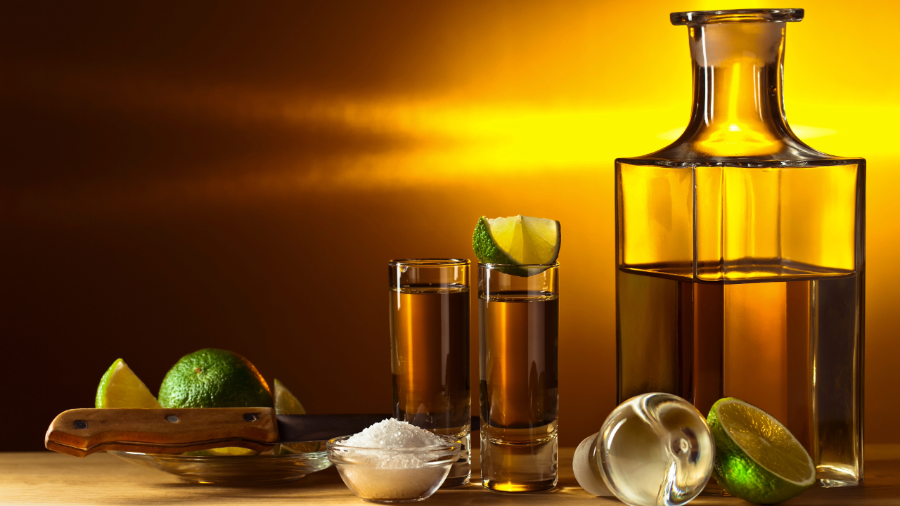 A bottle of premium tequila, shots, limes, and everything needed for a perfect tequila tasting session