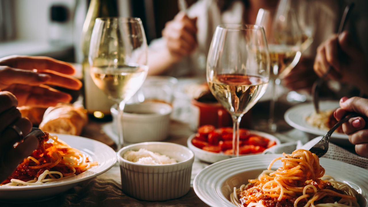 A Family dining on pasta and wine, one of the classic food and wine pairings