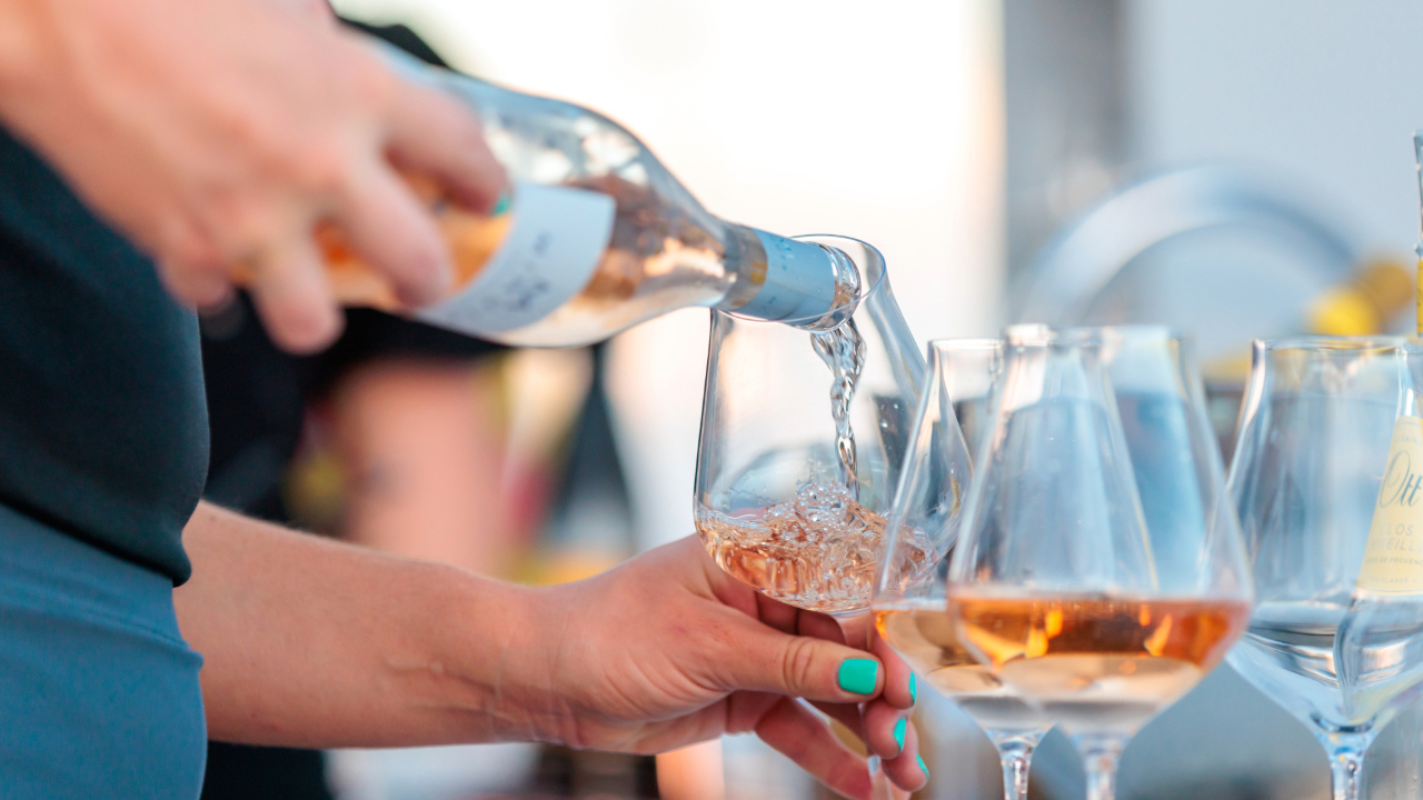 A woman pouring wine into glasses for congruent and contrasting flavor profiles